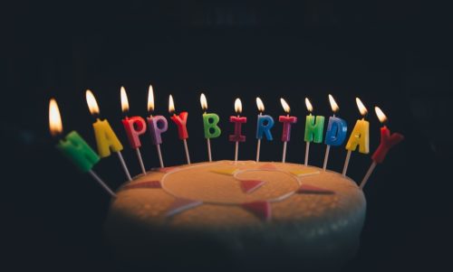 tort udekorowany świeczkami z napisem happy birthday