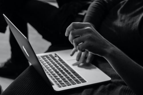 czarno-biała fotografia kobiety korzystającej z laptopa