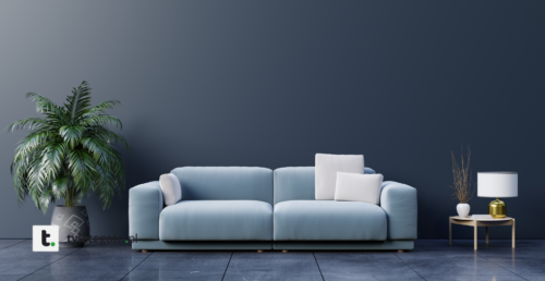 błękitna kanapa z białymi poduszkami dekoracyjnymi na tle grafitowej ściany