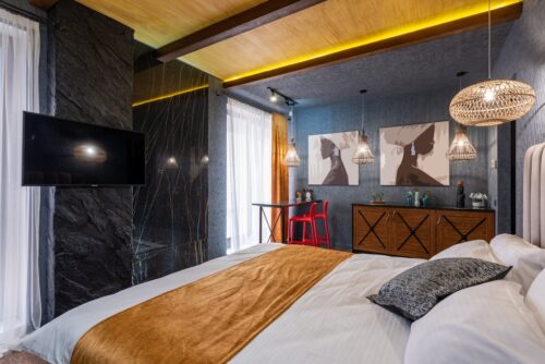 sypialnia urządzona w ciemnych kolorach z dodatkiem koloru złotego