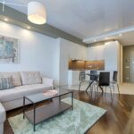 Salon z aneksem kuchennym – jak spójnie połączyć strefy za pomocą mebli na wymiar?